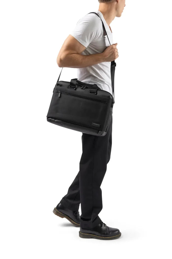 Hedgren BYTE 15.6" Laptop Briefcase with RFID in Black, carried on its shoulder strap by a man in a white tee