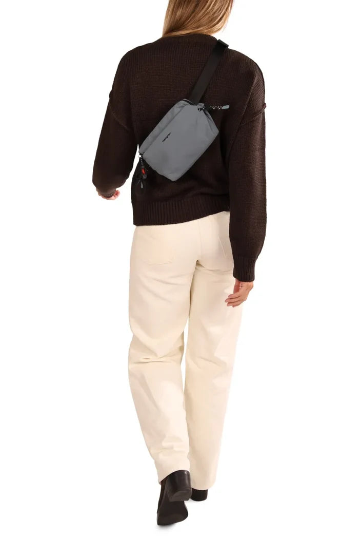 Hedgren JUN Waistbag in Black, worn across the back over a brown knit, seen from behind