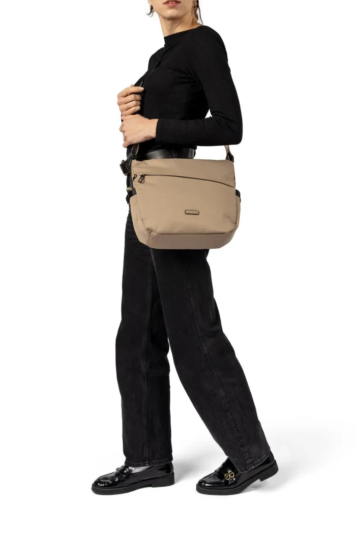 Hedgren MILKY WAY Large Crossover Shoulder Bag in Black, worn crossbody at the hip by a woman in a black top and dark jeans