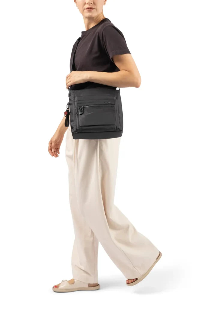 Hedgren ORVA Crossbody Bag with RFID Pocket in Black Gradient Print, worn crossbody at the waist by a woman in a dark tee and cream trousers
