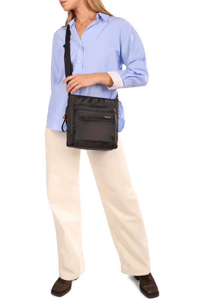 Hedgren ORVA Crossbody Bag with RFID Pocket in Black Gradient Print, worn crossbody at the hip by a woman in a blue shirt and cream trousers