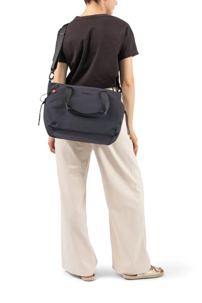 Hedgren SATOSHI 14" Laptop Tote in Black, carried on the shoulder by a woman in a brown tee, seen from behind