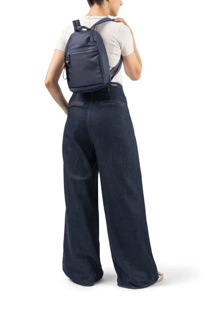 Hedgren VOGUE Small Backpack in Black, swung onto one shoulder by a woman in wide denim trousers
