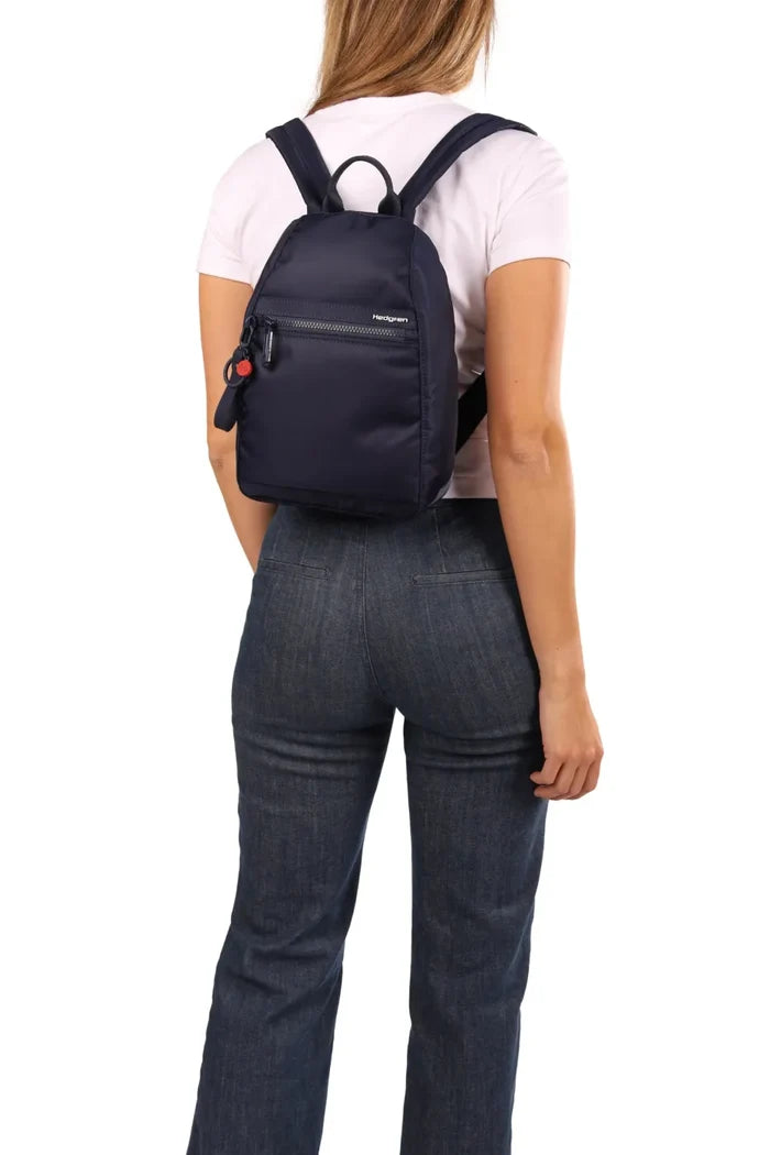 Hedgren VOGUE Small Backpack in Quilted Black, worn on both shoulders over a pale tee and jeans, seen from behind